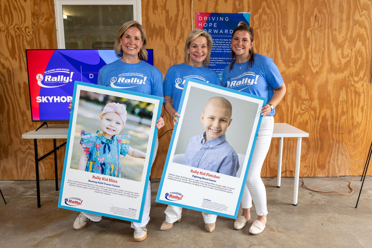 Emily Kallos, Dean Crowe, and Gianna Dubiel holding Rally Kid posters at the ATL station launch